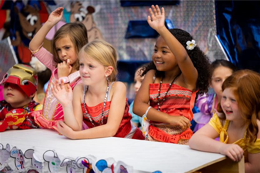 Girls smiling and waving on parade float